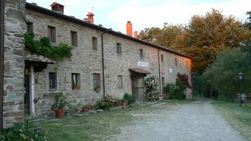 A stone building with a sign reading "CIN CASTIR" and a gravel path leading to it.