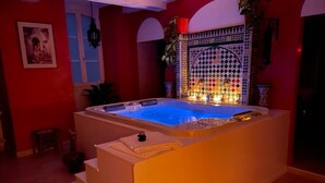 Un jacuzzi con borde de azulejos y un arco decorativo.