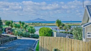 A coastal property with a view of the sea and a mountain in the distance. - The Blue Cottage with WiFi- Waipu Holiday Home (Waipu Cove)