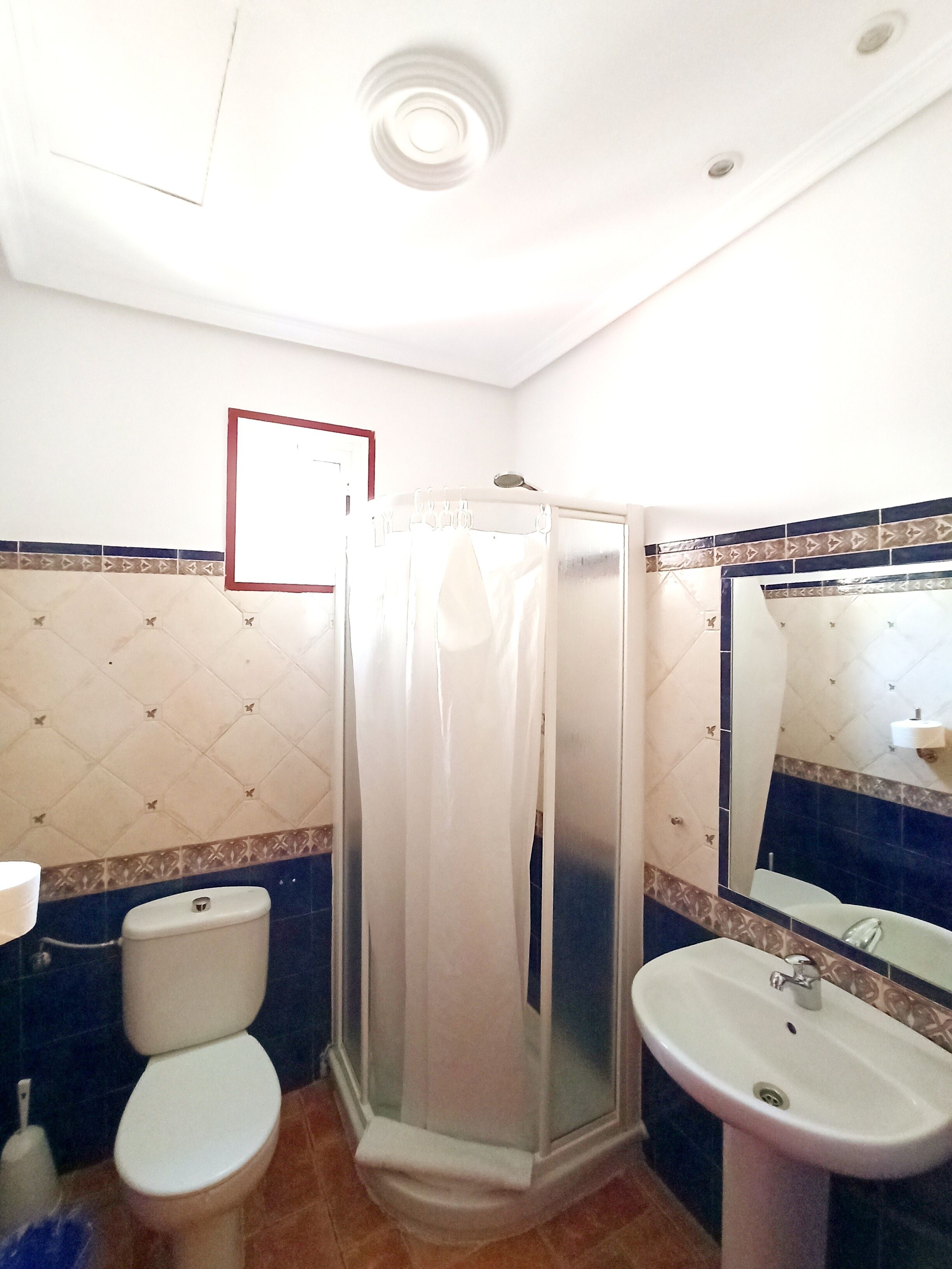 A bathroom with a toilet, a sink, and a shower stall.