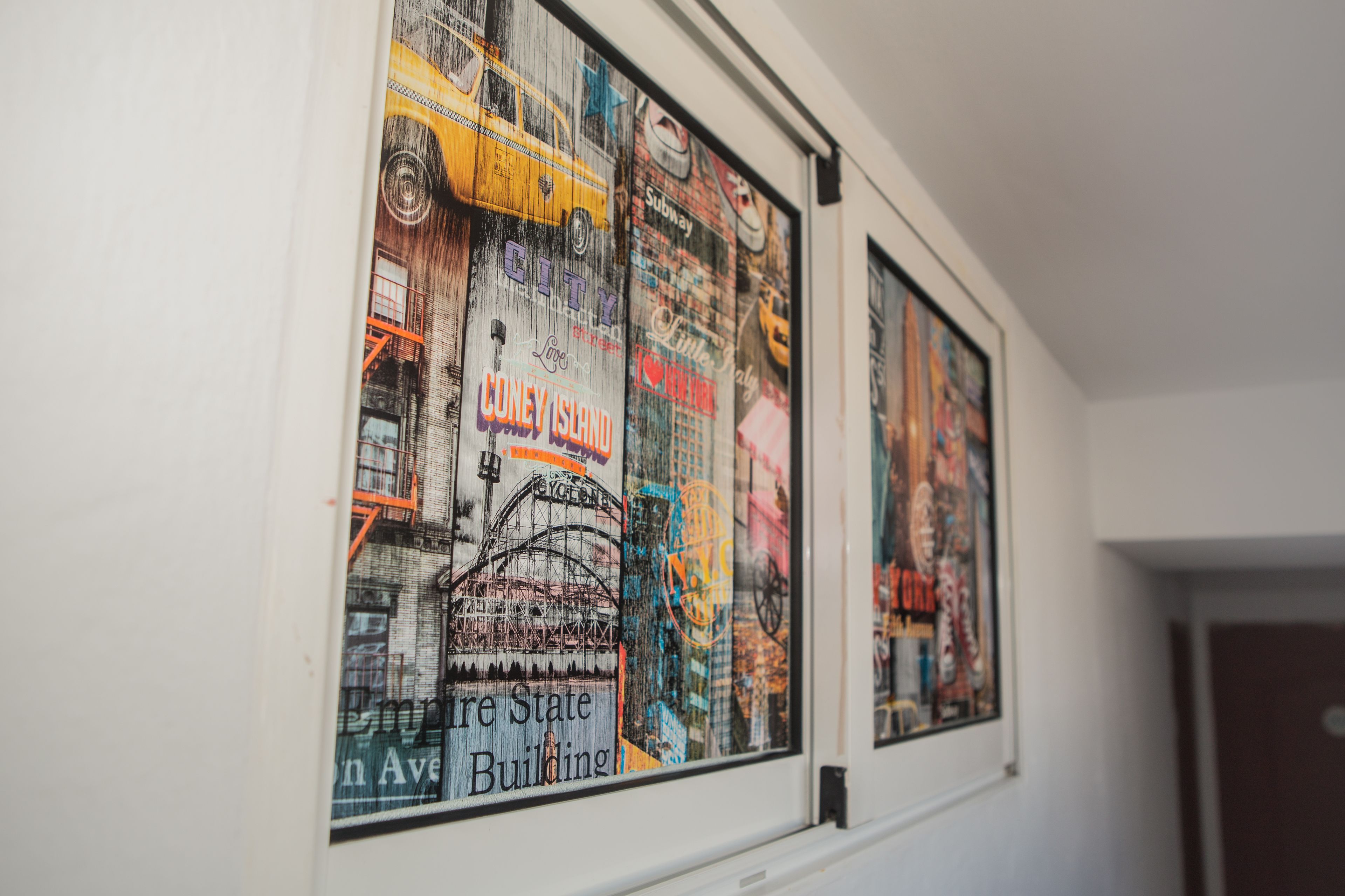 Dos carteles enmarcados de monumentos emblemáticos de Nueva York en una pared.