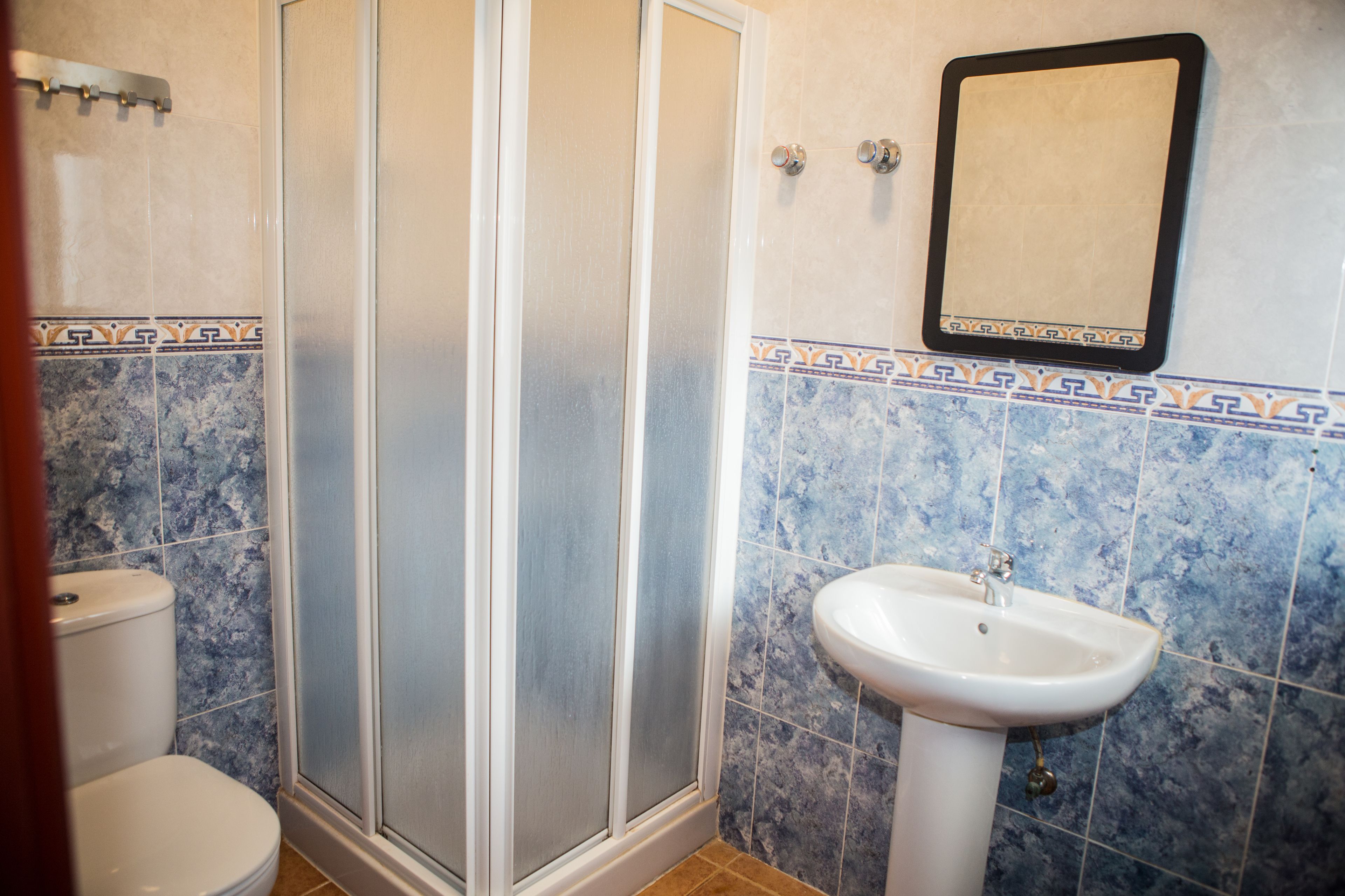 A bathroom with a shower, toilet, and sink.