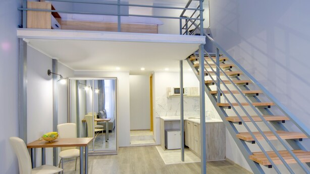 Um interior moderno com área de jantar, cozinha e escadaria.