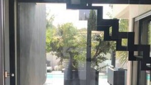 Entrada de un edificio moderno con una escalera geométrica y una escultura de oso polar en el suelo.