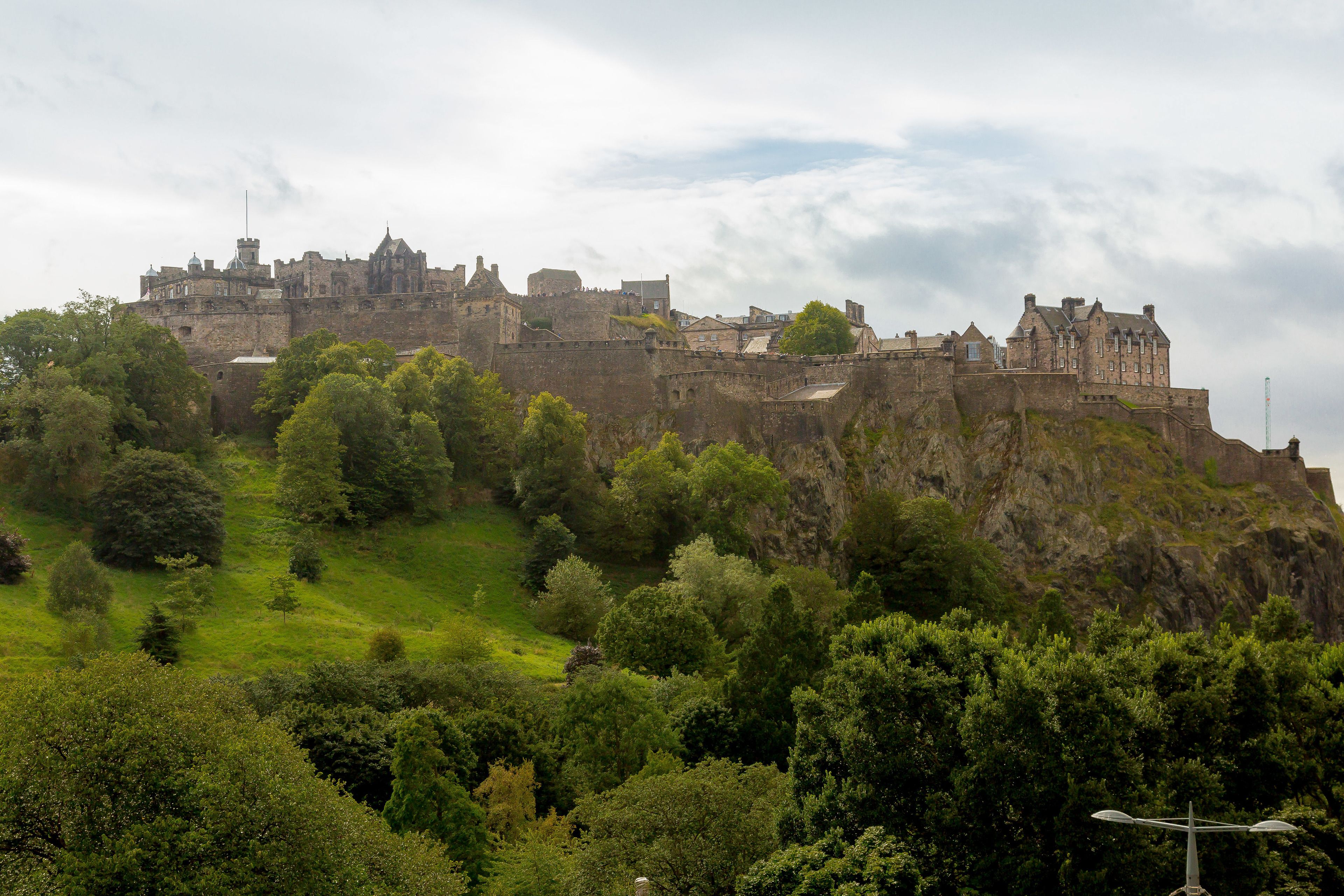 Un château historique perché sur une colline, entouré d’une végétation luxuriante.