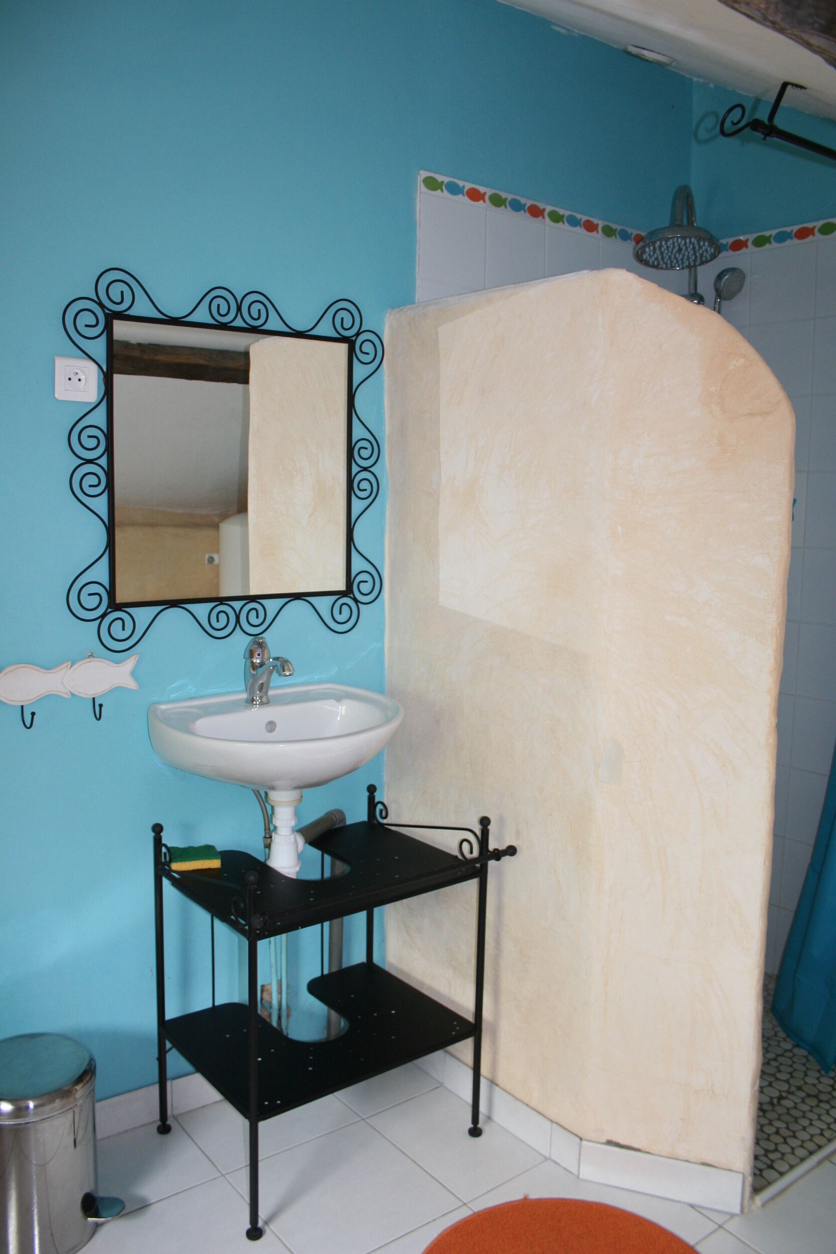 A bathroom with a sink, mirror, and shower.