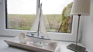 Un velero modelo sobre una mesa junto a una ventana con una lámpara.