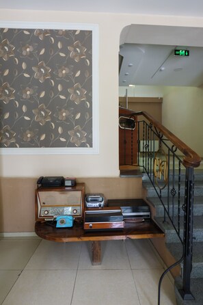 A staircase with a wooden handrail and metal balusters, leading to an upper floor.