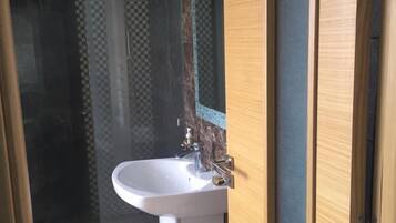 Une salle de bain moderne avec un lavabo blanc, un miroir et un motif à carreaux sur le mur.
