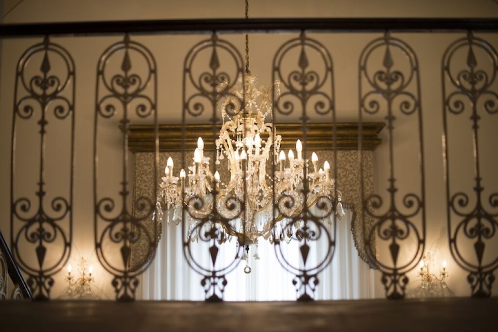A chandelier with multiple lights hanging from a decorative metal frame.