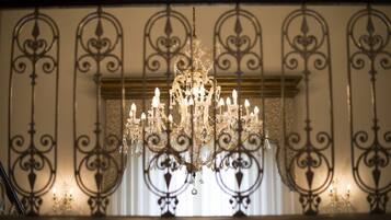 A chandelier with multiple lights hanging from a decorative metal frame.