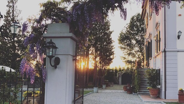 A gravel pathway leading to a white building with a wrought iron gate and a lantern post. - Relais Villa Scarfantoni B&B (Montemurlo)