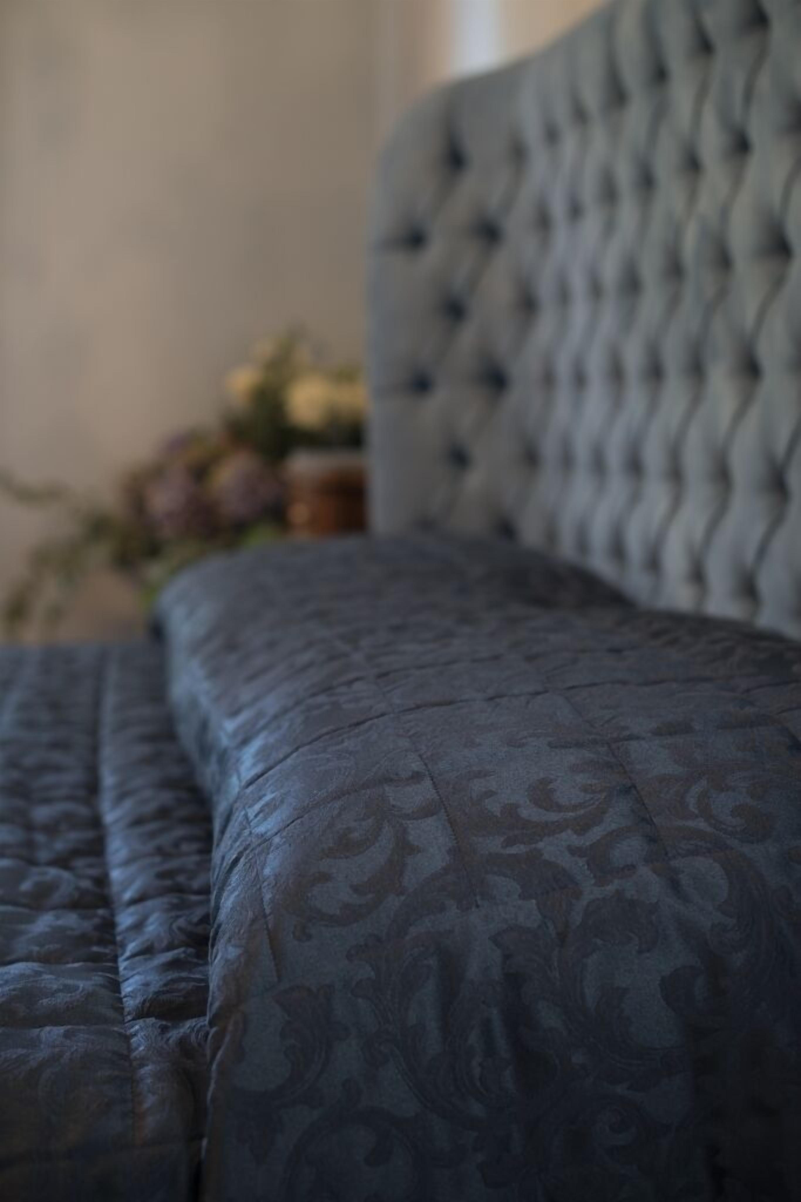 A close-up of a tufted headboard with a patterned fabric.