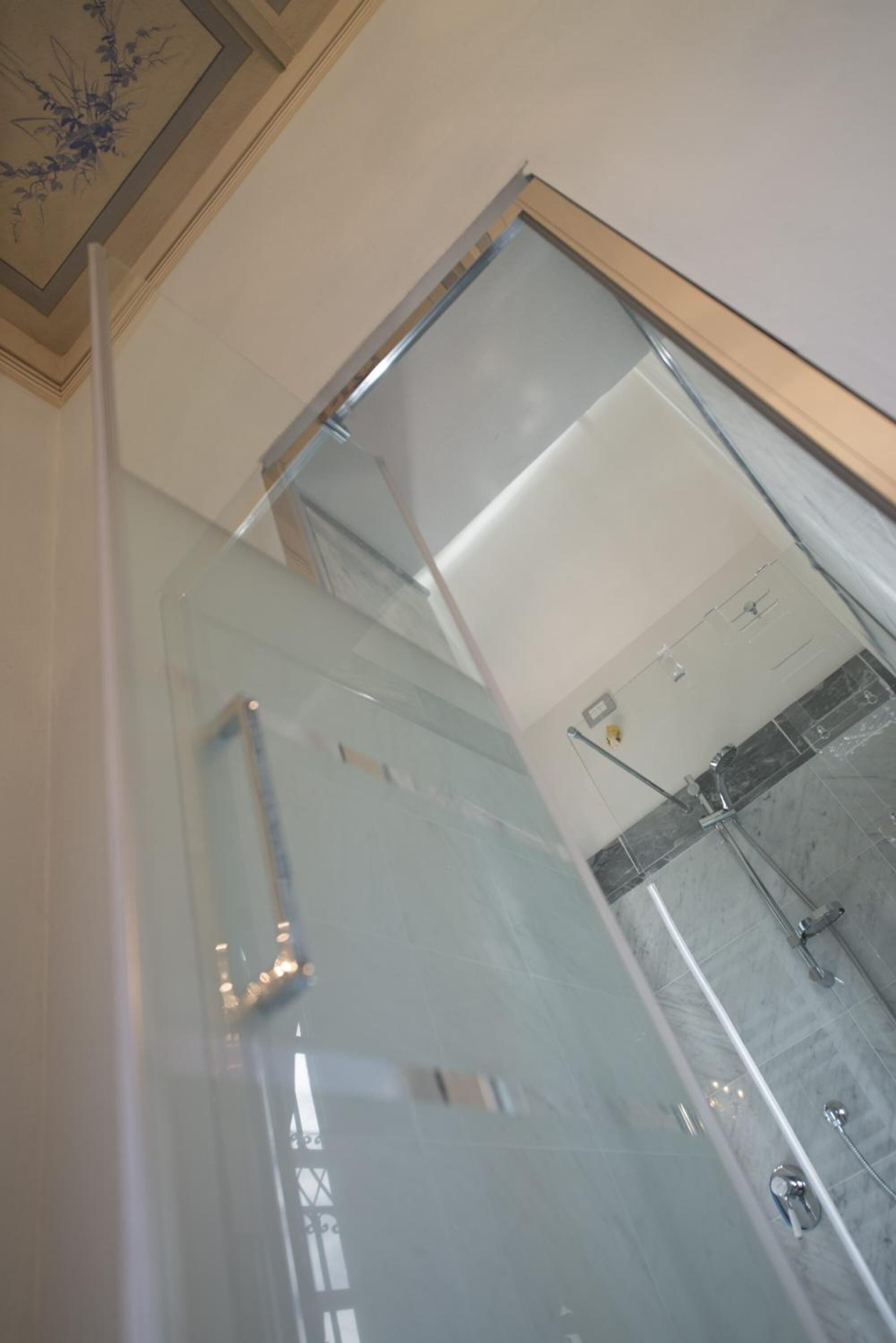 A glass-enclosed shower with a visible showerhead and control panel.