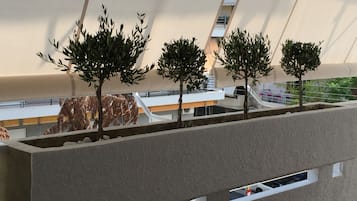 A modern architectural model with a minimalist design, featuring a series of trees and a curved structure.
