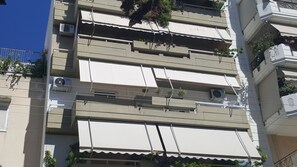 A multi-story building with balconies, air conditioning units, and potted plants. - Captain's Luxury Suite (Nea Smirni)