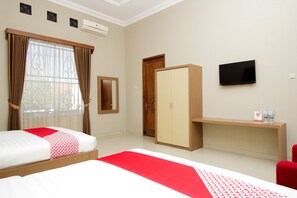 Ein Hotelzimmer mit Bett, Schrank, Fernseher und Schreibtisch mit Stuhl.