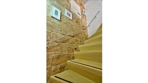 Una escalera con paredes de piedra y escalones amarillos.