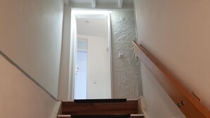 A staircase with a wooden handrail and a textured wall. - Lovely City House (Meerbusch)