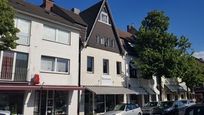 A street view with buildings, cars, and a clear sky. - Lovely City House (Meerbusch)