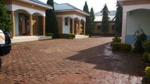 Un patio con un sendero empedrado, rodeado de edificios con arcos y columnas.