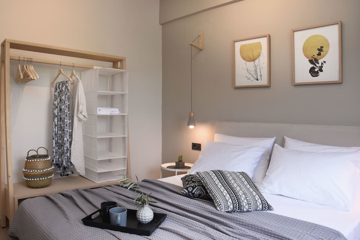 Un dormitorio ordenado con cama, mesita de noche y armario.