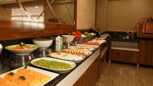 A buffet with various food items including fruits, vegetables, and meats. - Van Hotel (Van)