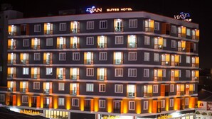 A multi-story hotel with a modern design, featuring balconies on each floor and illuminated windows. - Van Hotel (Van)