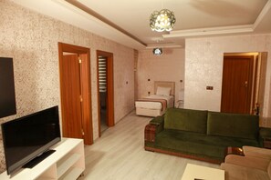 Suite, vista a la ciudad | Área de sala de estar | Televisión LCD