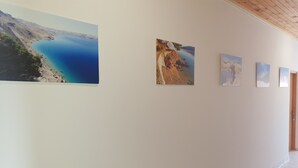 A hallway with four framed landscape paintings on the wall. - Apartments Dalmatinka Metajna Novalja (Novalja)