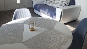 A modern bedroom with a bed, a round table with a menu, and a chair. - Apartments Dalmatinka Metajna Novalja (Novalja)