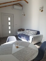 Un dormitorio moderno con cama, una mesa redonda con un menú y una silla.