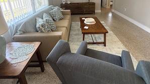 A living room with a sofa, armchairs, a coffee table, a TV, and a ceiling fan. - Amazing beach getaway! (Redington Beach)