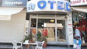Ett hotell med en väl synlig skylt, en butik med skyltdockor som visar upp kläder och några krukväxter utanför.