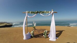 Romantic beachside wedding setup with a beautiful arch and floral decorations.