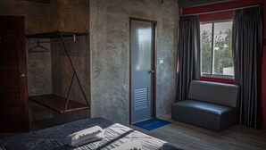 A bedroom with a bed, a hanging chair, a wardrobe, and a door.