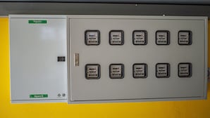 A utility room with a grey electrical panel and a door labeled "Schneider Electric."