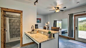 Une cuisine moderne dotée d’un îlot central, d’un espace douche et d’un coin repas avec vue.