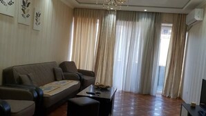 A living room with a sofa, armchairs, a coffee table, and a TV. - Apartment on Kandelaki Str. (Tbilisi)