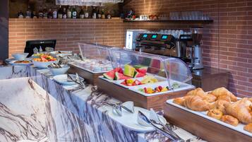 Un bufé de desayuno con diferentes opciones de comida, una máquina de café y una selección de vinos en estanterías.