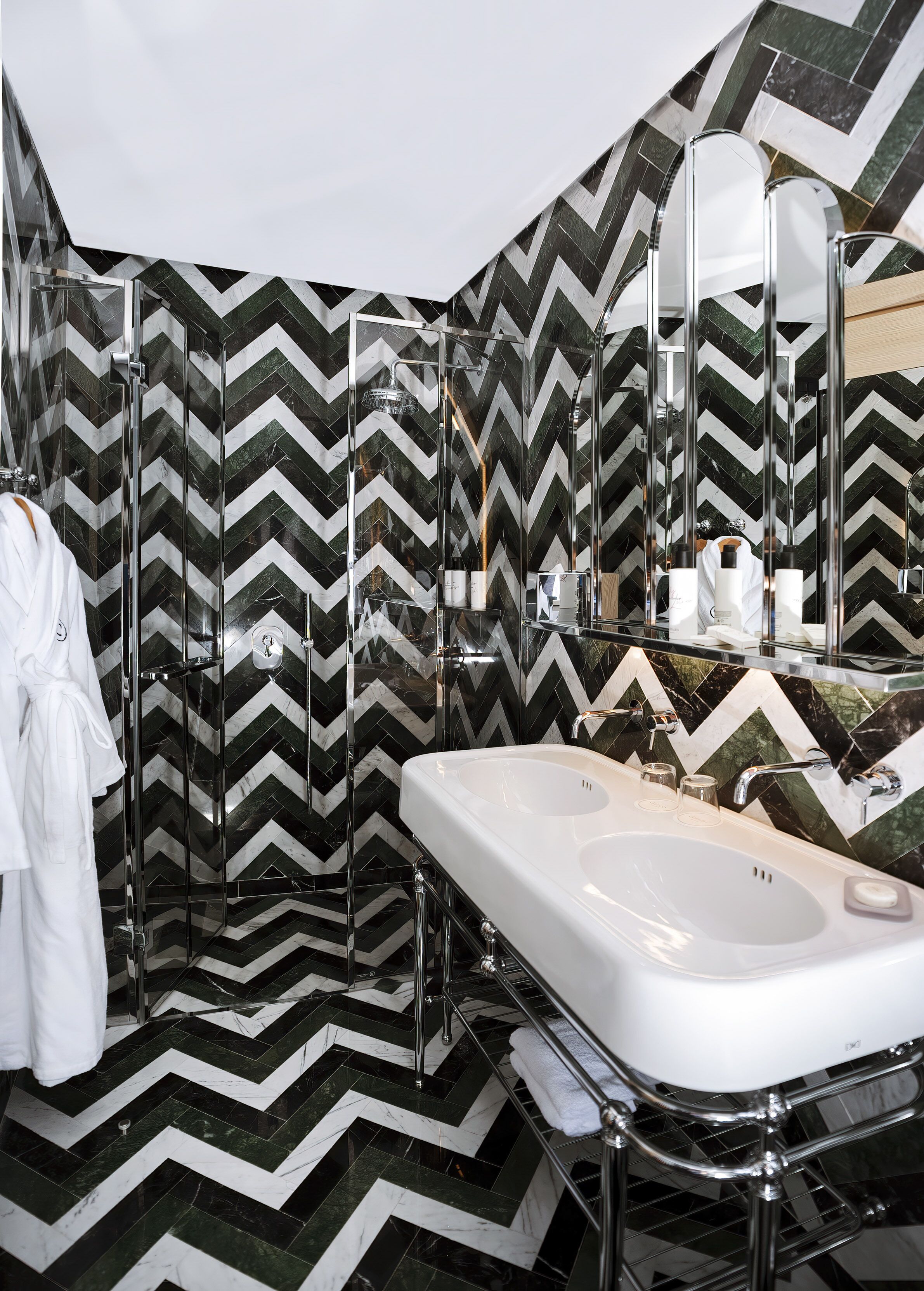 A modern bathroom with a large mirror, a white sink, and a shower enclosure.