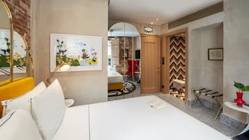 Una habitación de hotel moderna con cama, escritorio, silla y baño visible a través de un arco.