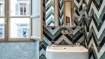 A bathroom with a mirror, sink, and window.