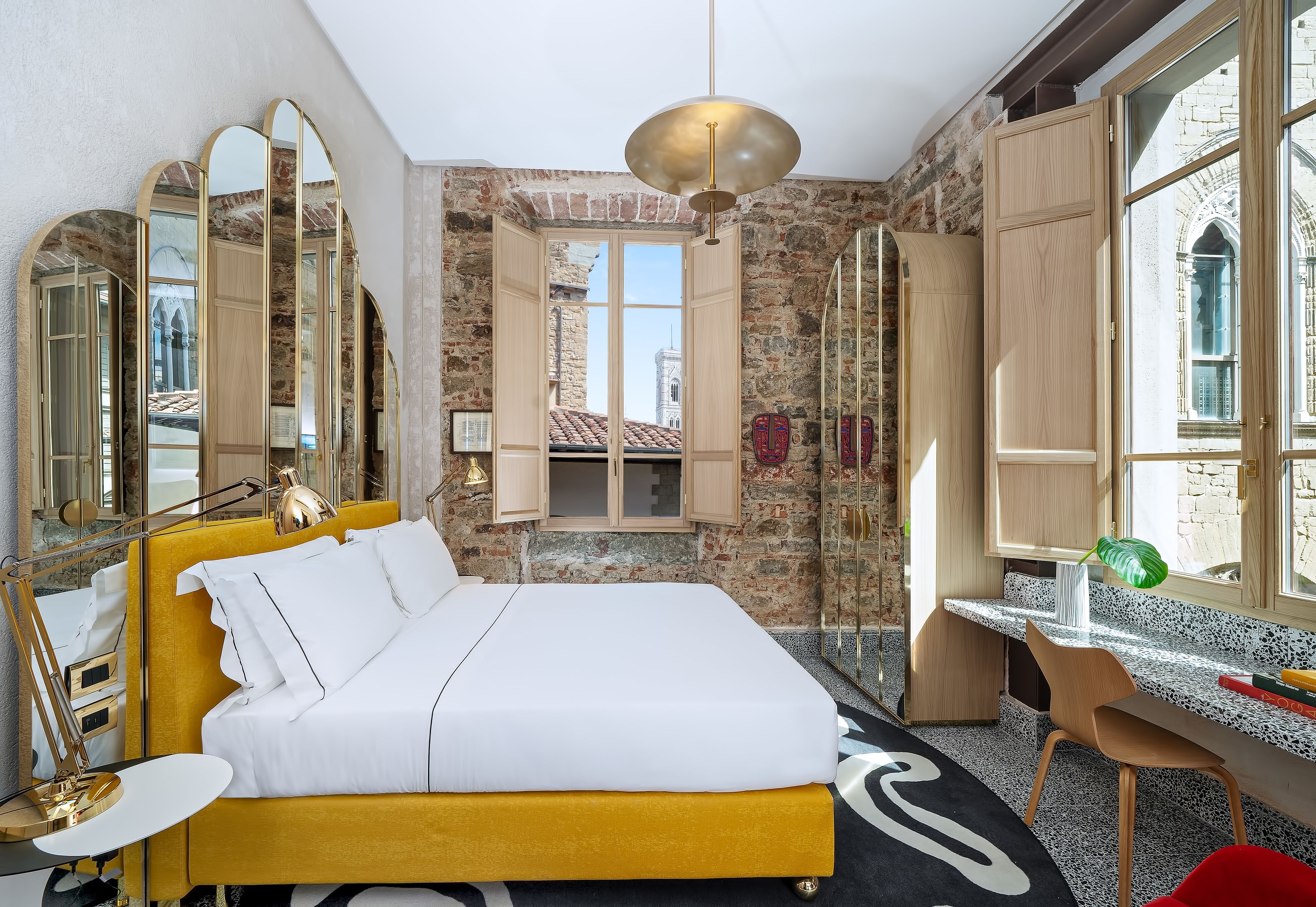Ein modernes Hotelzimmer mit Bett, Schreibtisch und Blick auf die Stadt.