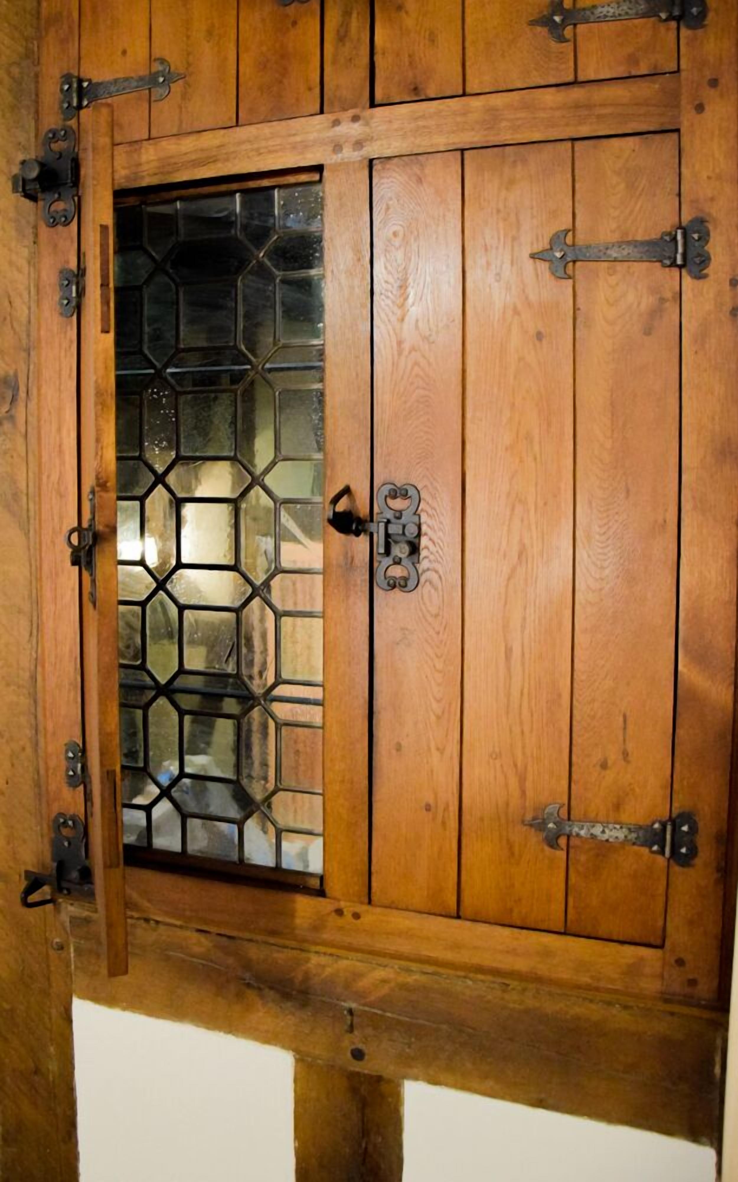 Una puerta de madera con un panel de vidrio que presenta un diseño geométrico.