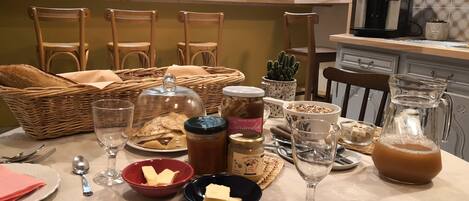 A dining table set with various food items, utensils, and a coffee machine.