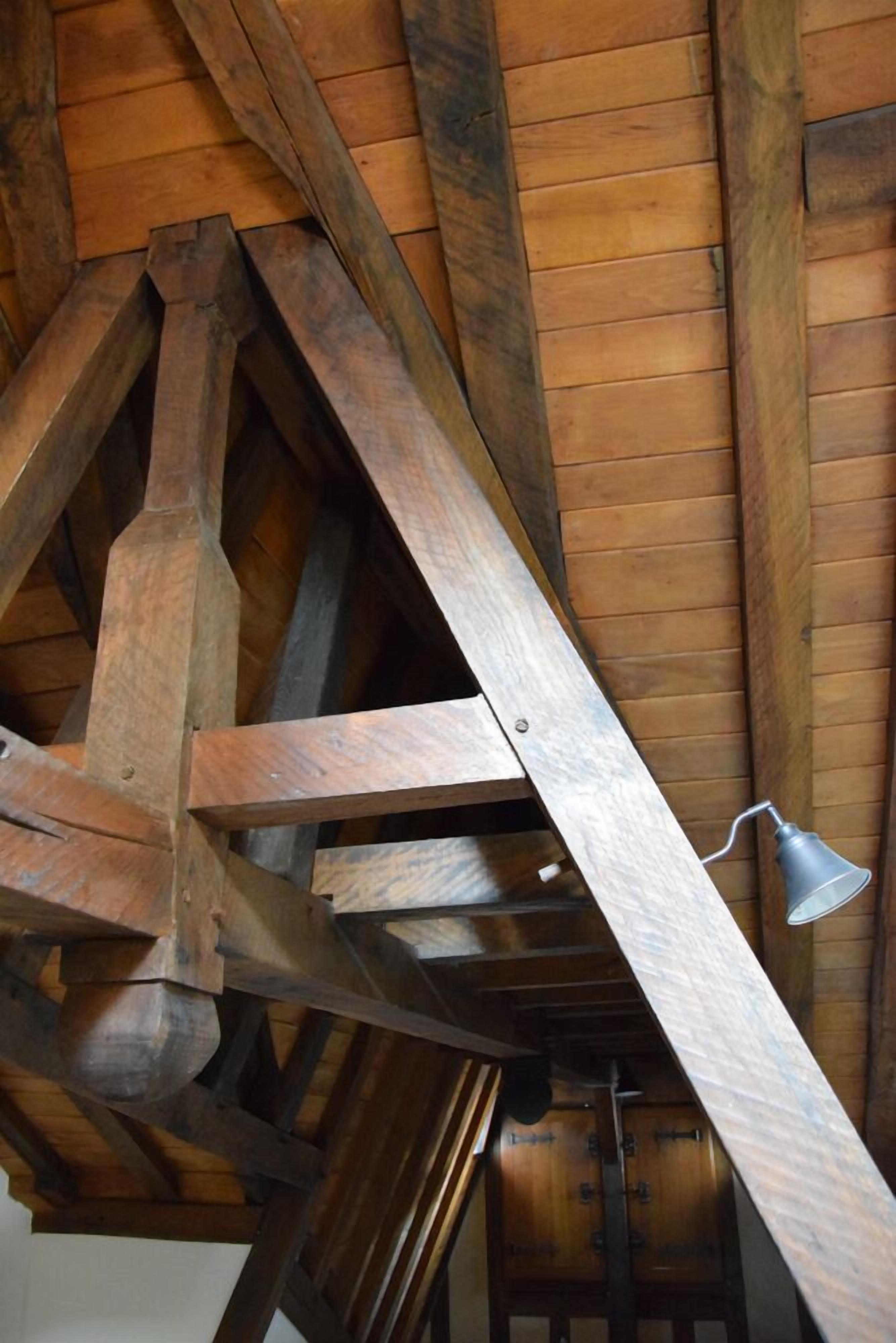 Une structure de plafond en bois avec des poutres apparentes et une cloche.