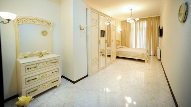 A hotel room with a large mirror, a wardrobe, a bed, and a television. - Apartment on Kostava str. (Tbilisi)