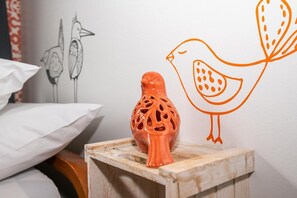 A wooden stool with a ceramic bird sculpture on top.