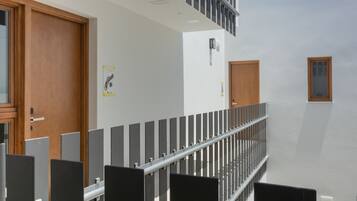 Un edificio moderno con una escalera, puertas de madera y barandilla de metal.